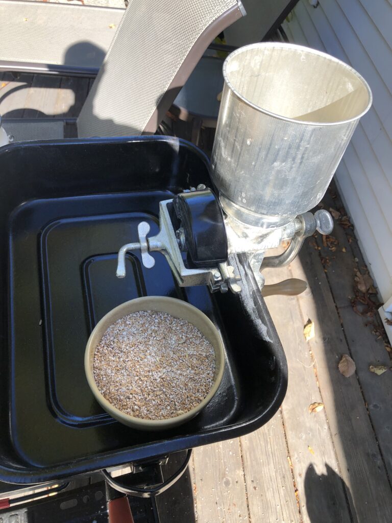 A Victoria metal grinder with a bowl of flour.